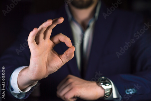 Businessman showing OK by his hand.  Reliable business or service concept