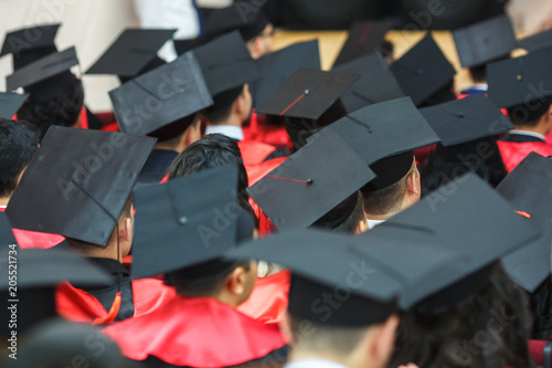 Foto Foreign medical students in square academic graduation caps and black raincoats