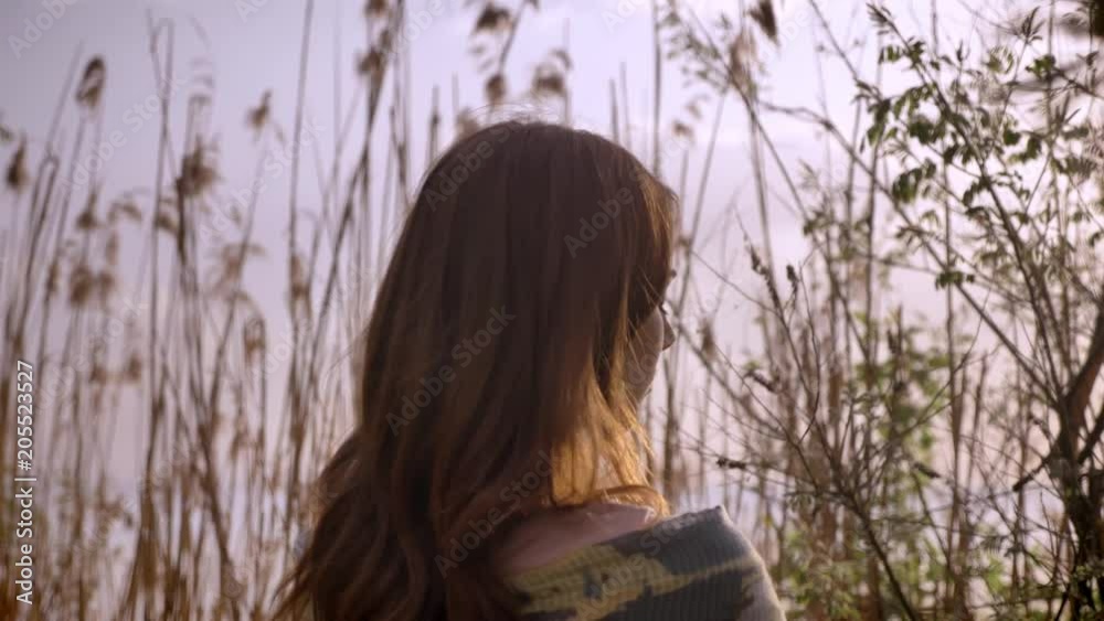 Young ginger lonely girl in a dress is standing in forest in nature, looking away, lost in thought 50 fps Young ginger lonely girl in a dress is standing in forest in nature, looking away, lost in thought 50 fps