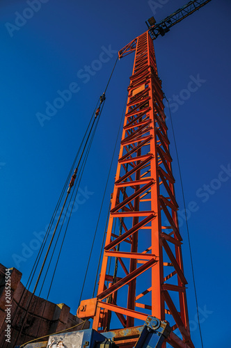 Close-up of crane in a construction area at sunset in Tielt. Charming and quiet village in the countryside, near Ghent and surrounded by agricultural fields. Western Belgium. Retouched photo. photo