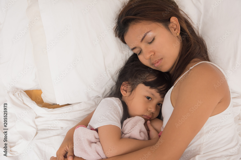 Cute little girl sleeping with mother in bed Cute little girl sleeping with mother in bed