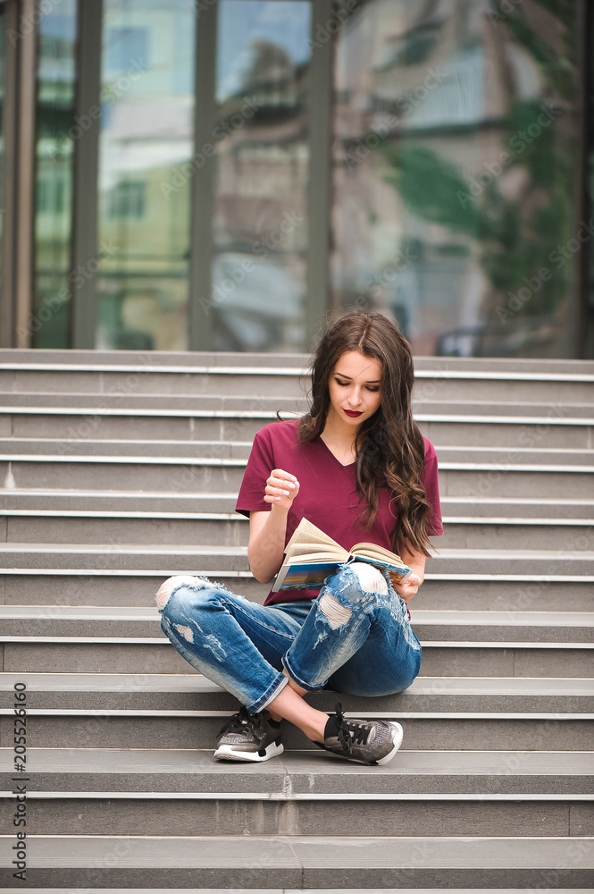 Young pretty woman sitting and reading a book enjoys of rest Young pretty woman sitting and reading a book enjoys of rest
