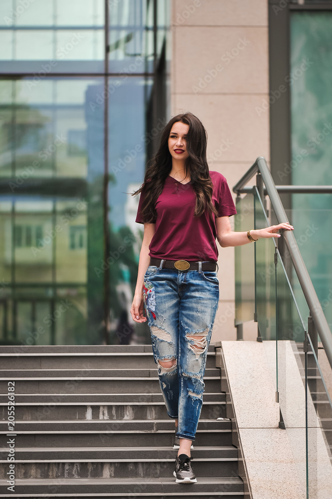 outdoor portrait of a stylish woman on the steps of shopping mall