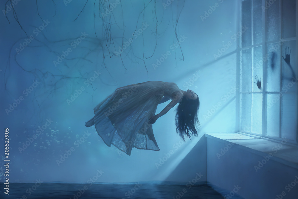 A ghost girl with long hair in a vintage dress. Room under water. A  photograph of