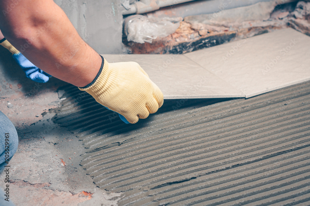 The tiler performs tile installation on the floor, finishing and facing works