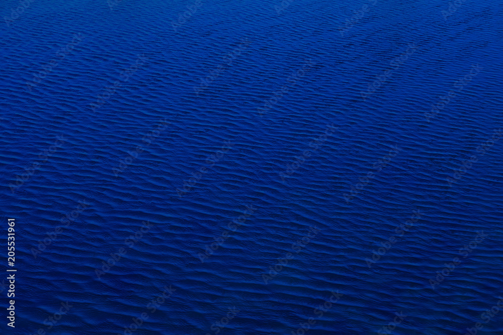 Fototapeta premium The dark shadow blue water surface has waves pattern for use as background and texture.