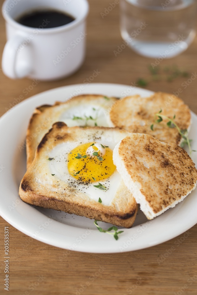 A heart-shaped fried egg in a slice of a toast A heart-shaped fried egg in a slice of a toast