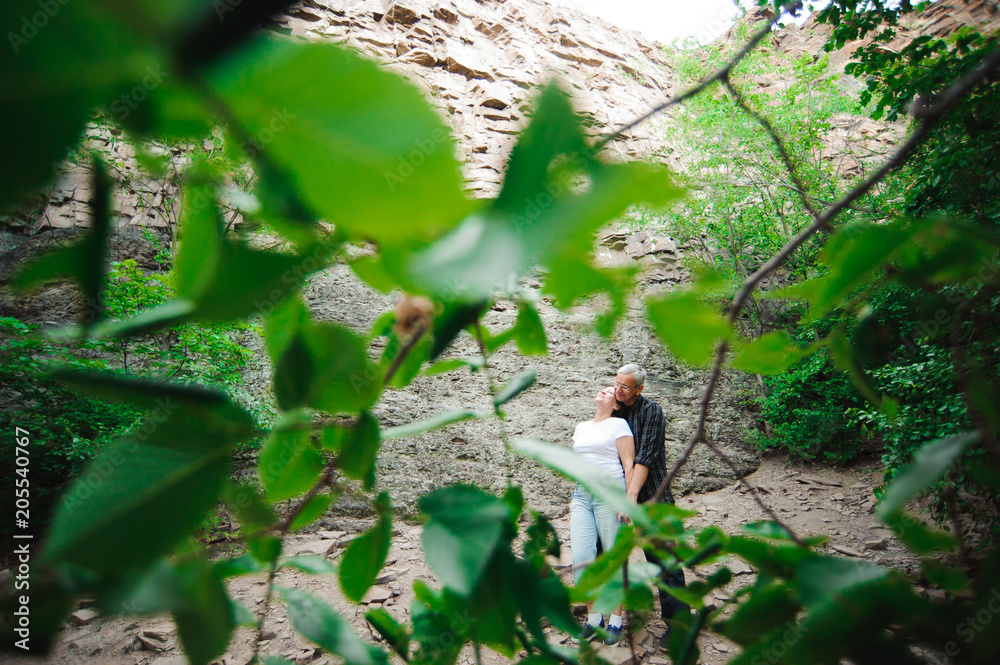 Active loving senior couple walking in beautiful summer forest - active retirement concept Active loving senior couple walking in beautiful summer forest - active retirement concept