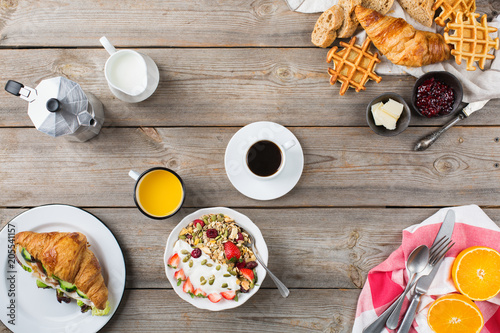 Breakfast table with waffles, granola, yogurt, pancakes, juice, coffee