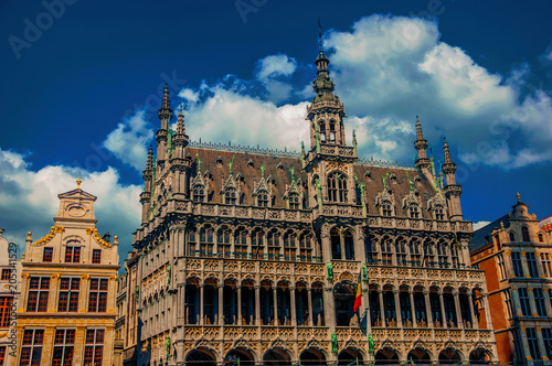 Richly decorated facade in Gothic style of Brussels City Museum and Belgian flag. Vibrant and friendly, is the country’s capital and administrative center of the EU. Central Belgium. Retouched photo