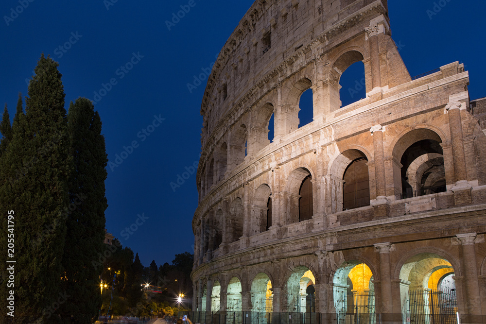 A section of the facade of the Colosseum (Flavian Amphitheatre) in Rome, Lazio, Italy during the blue hour.