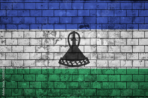 Lesotho flag is painted onto an old brick wall photo