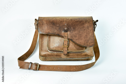 Old vintage leather shoulder bag for rider. Rustic design for tough field use leather bag. Shot on white background.