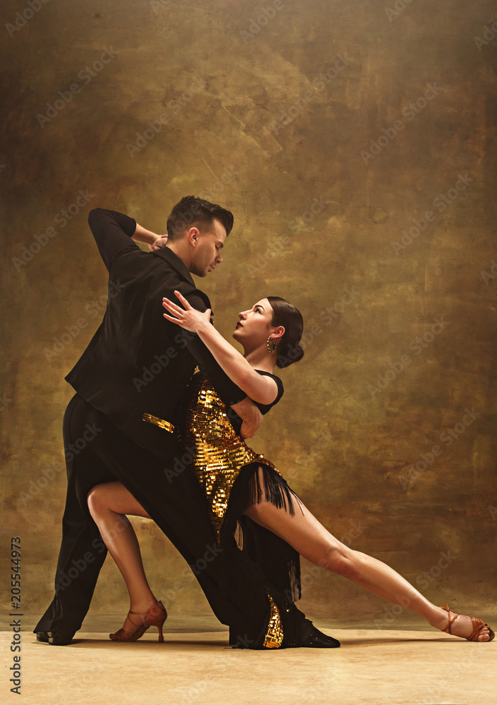 Dance ballroom couple in gold dress dancing on studio background. - obrazy, fototapety, plakaty 