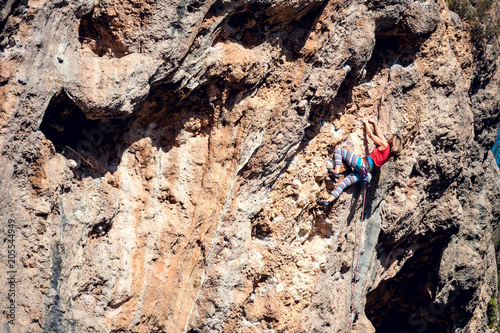 A woman climbs the rock.