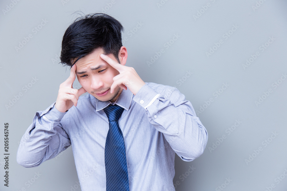 Portrait stressed businessman: Attractive guy gets headache because charming handsome business man work too hard and get stressed or asian guy get office syndrome that makes him painful, copy space Portrait stressed businessman: Attractive guy gets headache because charming handsome business man work too hard and get stressed or asian guy get office syndrome that makes him painful, copy space