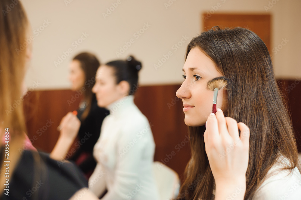 Professional makeup artist working with beautiful young woman Professional makeup artist working with beautiful young woman
