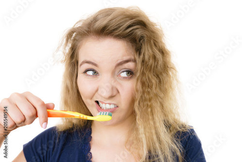 Grumpy tired woman brushing teeth, isolated