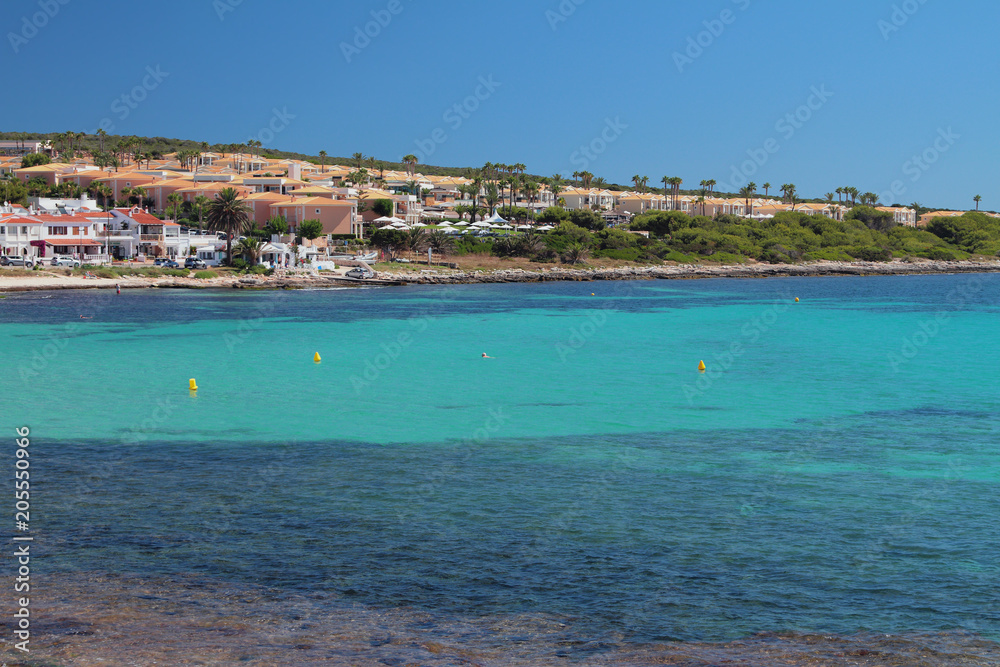 Sea gulf and resort on coast. Punta Prima, Minorca, Spain