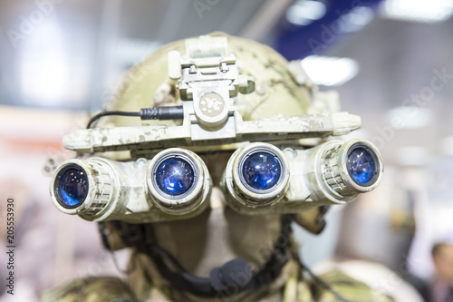 Army combat helmet are on, his face closed by using optical sights and night vision