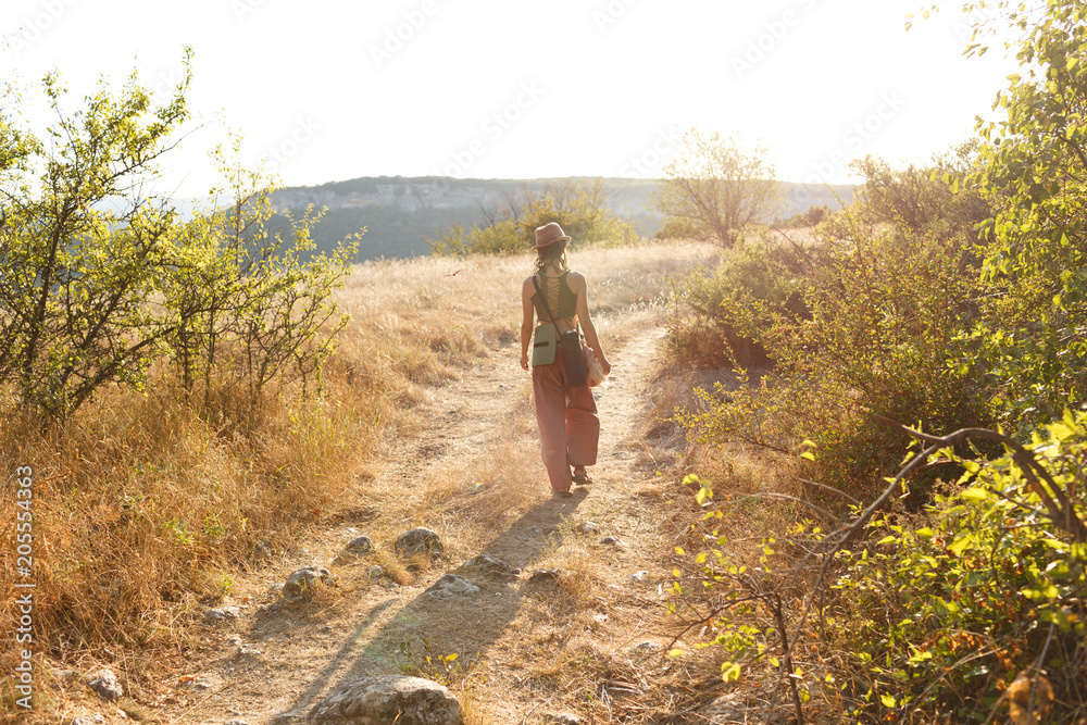 Fototapeta premium the traveler goes towards the mountains at sunset
