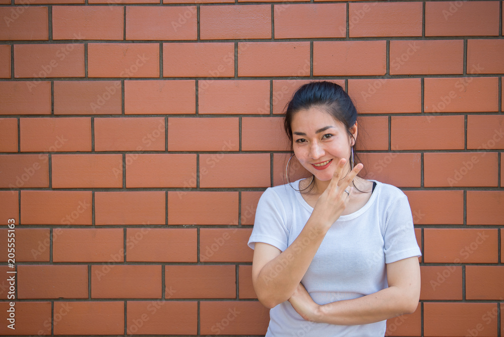 Portrait of beautiful asian chic girl pose for take a picture on brick wall,Lifestyle of teen thailand people,Modern woman happy concept Portrait of beautiful asian chic girl pose for take a picture on brick wall,Lifestyle of teen thailand people,Modern woman happy concept