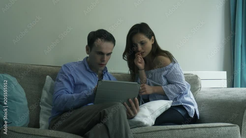 Young couple win lottery bingo gambling from Tablet. Handheld of millennial couple gambling on a tablet, then winning and celebrating Young couple win lottery bingo gambling from Tablet. Handheld of millennial couple gambling on a tablet, then winning and celebrating