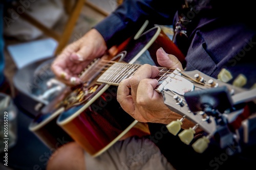 Wrinkled hands of man holding and play guitar