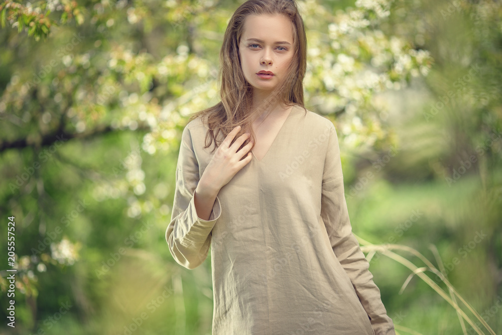 Beautiful young girl with her hair down next to a flowering fruit tree in a spring garden. Beautiful young girl with her hair down next to a flowering fruit tree in a spring garden.