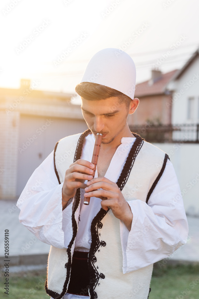 young man in traditional albanian costume playing flute in front of nature  meadow and evening dusk Stock Photo | Adobe Stock