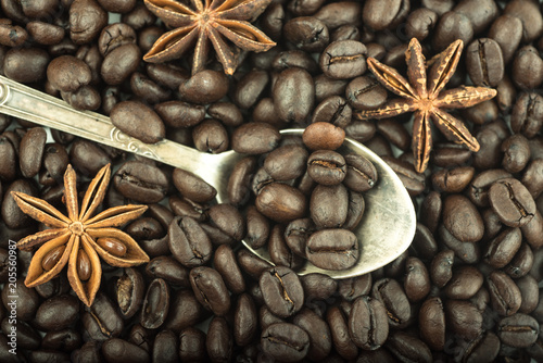 Old antique silver spoon, roasted coffee beans, anise seeds. Top View. Close up.