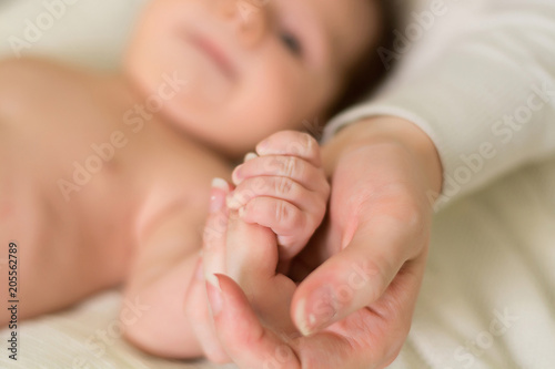 the hand of the newborn in the hands of the mother