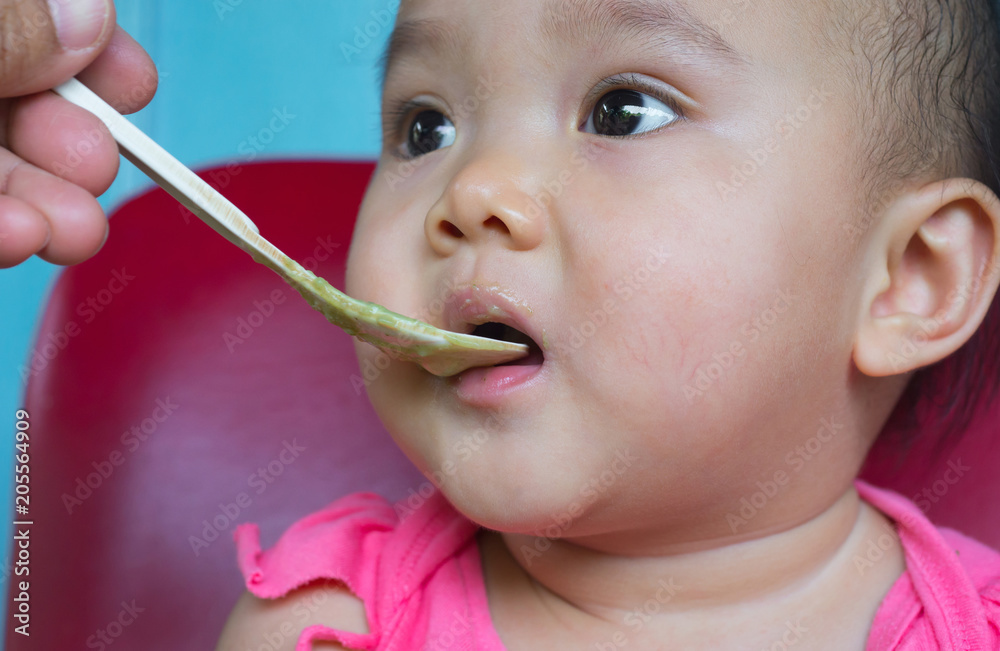 Faces and gestures of Asian babies who are eating food.