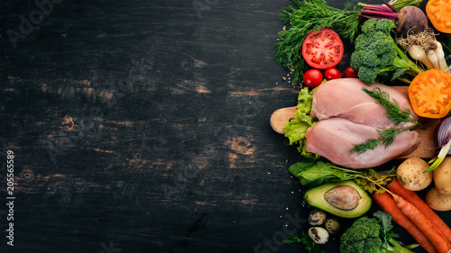 Chicken breast and fresh vegetables. Healthy food. On a black wooden background. Top view. Copy space.