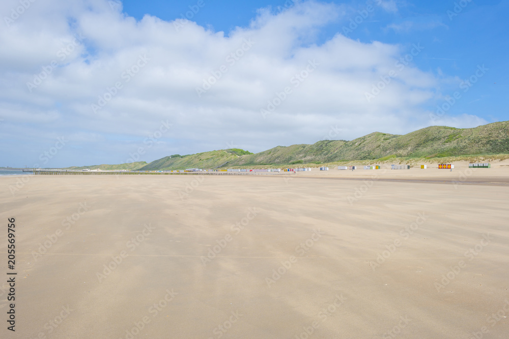 Beach cabins along hilly dunes on a recreational beach in sunlight in spring Beach cabins along hilly dunes on a recreational beach in sunlight in spring