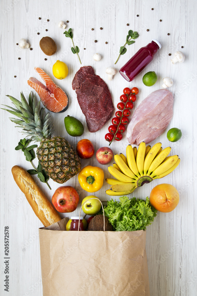 Paper bag of various healthy food on white wooden background, from ...