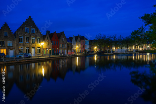 View of a canal and old historical buildings in Bruges, Belgium at dusk