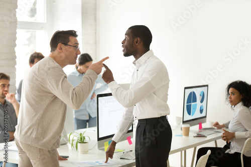 Multiracial african and caucasian colleagues disputing having disagreement at work blaming each other in mistake, diverse coworkers arguing about project, having conflict fight at workplace concept