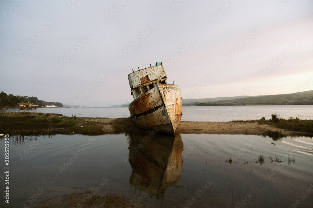 Abandoned boat at beach against sky during sunset Abandoned boat at beach against sky during sunset