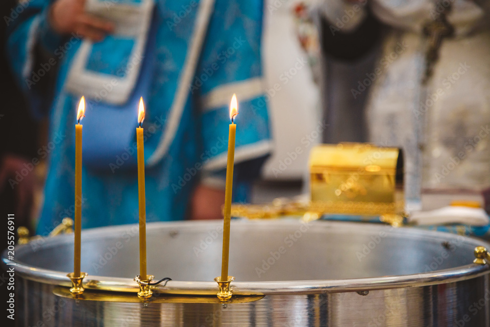 Christening in the church, candles at children baptismal font. Details in the orthodox christian church Christening in the church, candles at children baptismal font. Details in the orthodox christian church