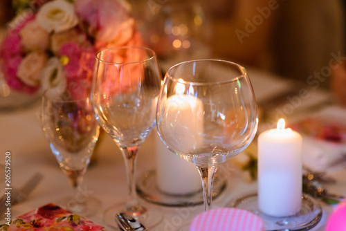 Dining table setting at Provence style, with candles, lavender, vintage crockery and cutlery, closeup. Beautiful wedding decoration with flowers pink violet purple white colors