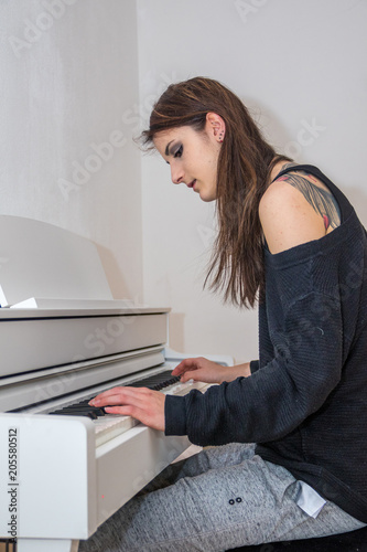 Junge Frau mit langen glatten Haaren spielt digitales Klavier photo