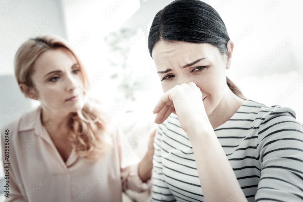 Im stuck. Disappointed unhappy tired woman sitting o the sofa touching her nose and crying. Im stuck. Disappointed unhappy tired woman sitting o the sofa touching her nose and crying.