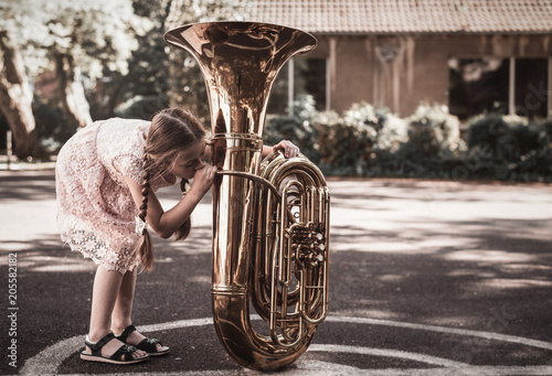 Mädchen probiert Tuba zu spielen photo