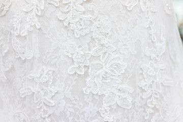 Macro closeup of lace wedding dress veil material, white garment textile with shiny rhinestones design