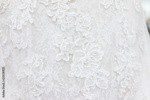 Macro closeup of lace wedding dress veil material, white garment textile with shiny rhinestones design