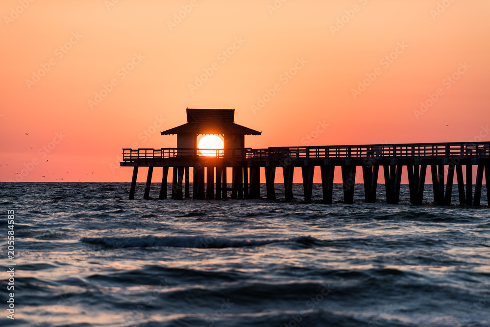 Naples, Florida pink, red and orange sunset in gulf of Mexico with sun