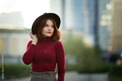 A young teenage girl in a black shirt and hat