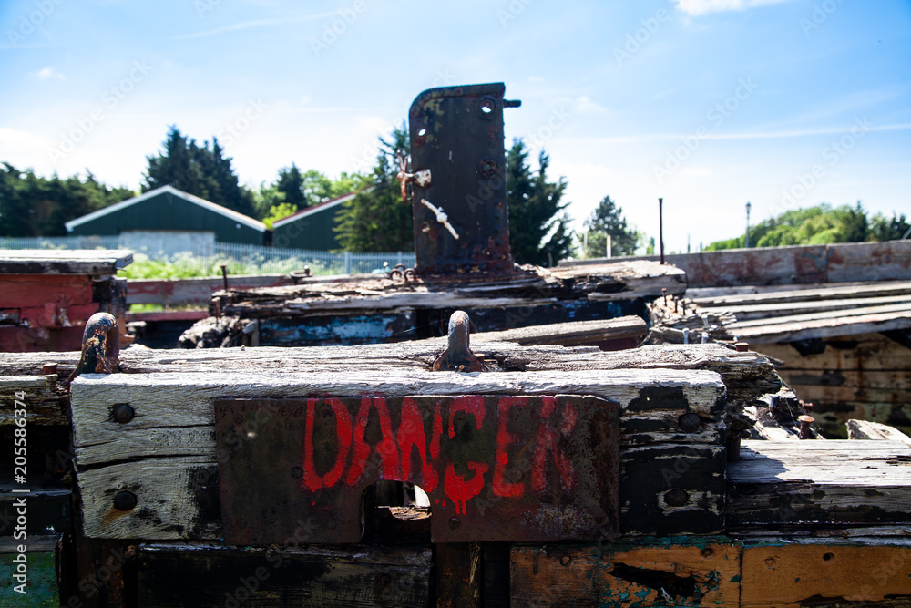 Danger sign on Rotting Wooden Structure of an old cargo  barge