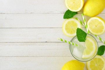 Sweet summer lemonade. Top view side border with copy space on a rustic white wood background.